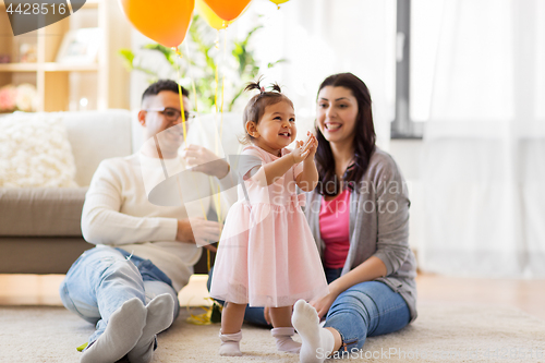 Image of happy baby girl and parents at home birthday party