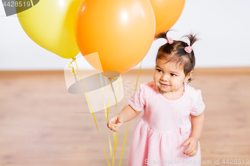 Image of happy baby girl with balloons on birthday party