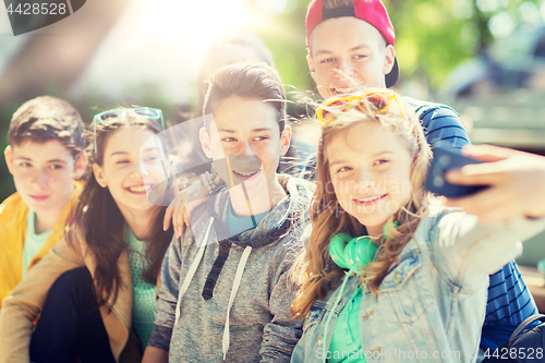 Image of happy teenage students taking selfie by smartphone