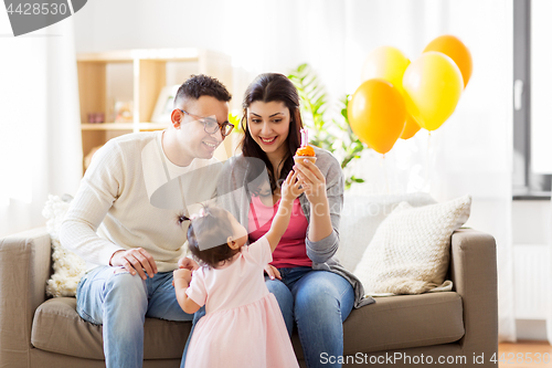 Image of baby girl with parents at home birthday party