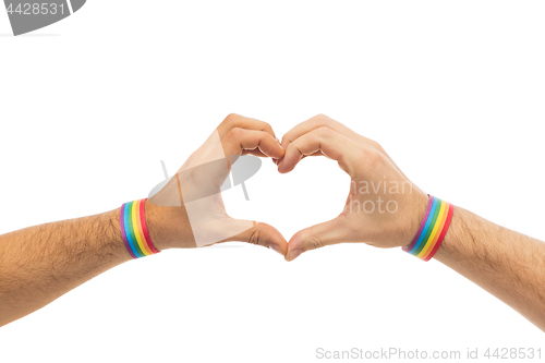 Image of male hands with gay pride wristbands showing heart