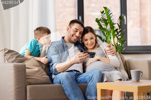 Image of happy family with smartphone at home