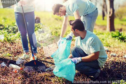 Image of volunteers with garbage bags cleaning park area