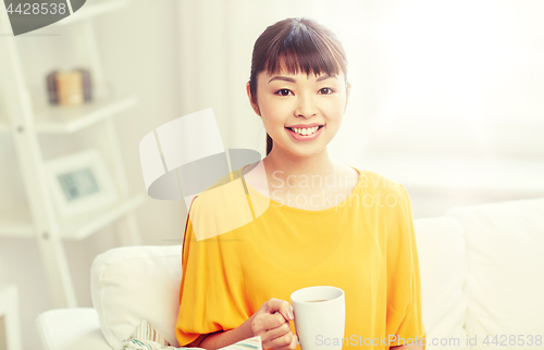 Image of happy asian woman drinking from tea cup