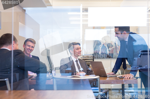 Image of Relaxed cheerful business people sitting and talking at corporate meeting.