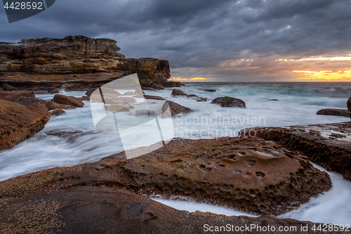 Image of Potter Point sunrise and rock flows icliffs