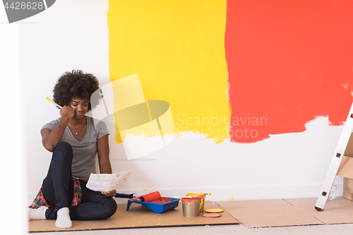 Image of back female painter sitting on floor