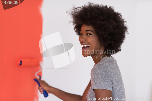 Image of black woman painting wall