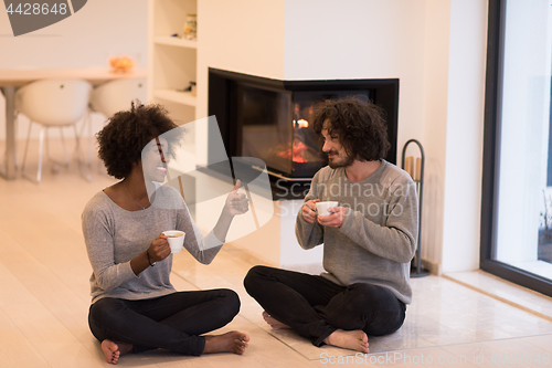 Image of multiethnic couple  in front of fireplace