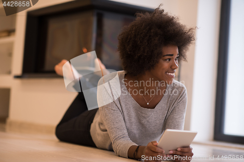 Image of black women using tablet computer on the floor