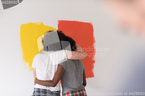 Image of multiethnic couple painting interior wall