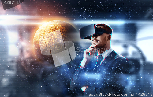 Image of businessman in virtual reality headset over space