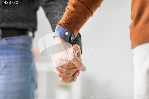 Image of close up of male gay couple holding hands