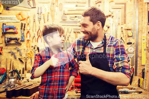 Image of father and little son making thumbs up at workshop