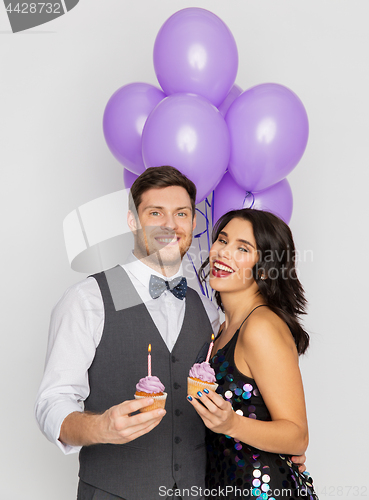 Image of happy couple with balloons and cupcakes at party