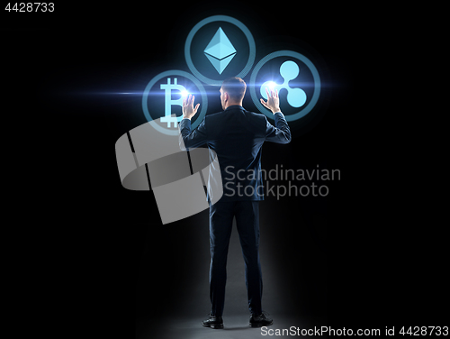 Image of buisnessman with cryptocurrency holograms