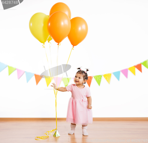 Image of happy baby girl with balloons on birthday party