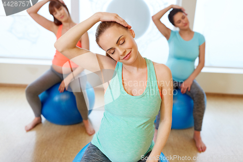 Image of pregnant women training with exercise balls in gym