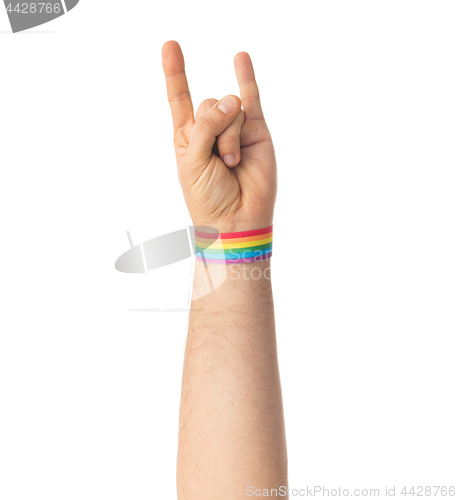 Image of hand with gay pride rainbow wristband shows rock