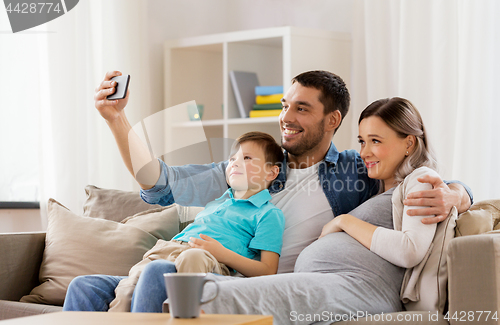 Image of happy family taking selfie with smartphone at home