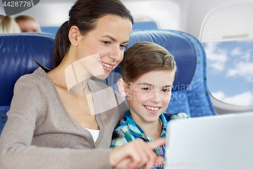 Image of happy family with tablet pc sitting in plane