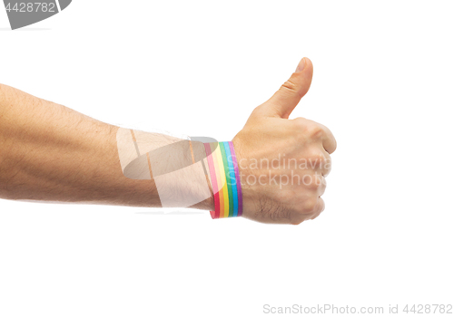 Image of hand with gay pride rainbow wristband shows thumb