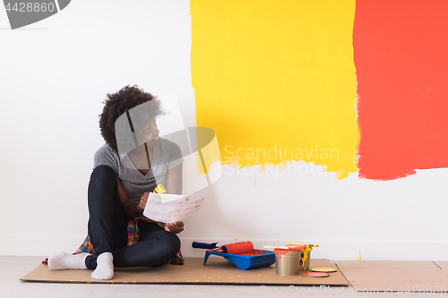 Image of back female painter sitting on floor