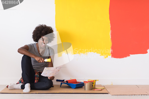 Image of back female painter sitting on floor