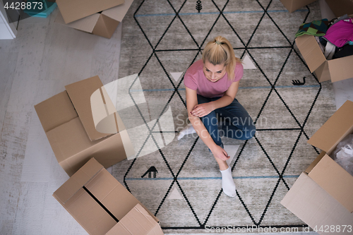 Image of top view of young beautiful woman sitting on the floor