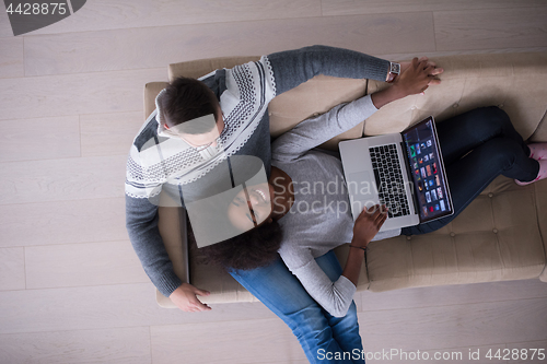 Image of happy multiethnic couple relaxes in the living room