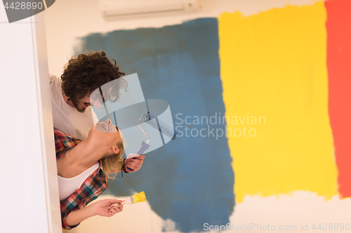 Image of portrait of a couple painting interior wall