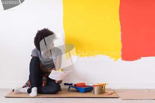 Image of back female painter sitting on floor
