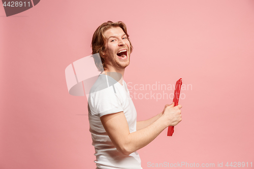 Image of The happy businessman with red laptop on pink