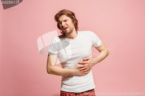 Image of Young man overwhelmed with a pain in the stomach .