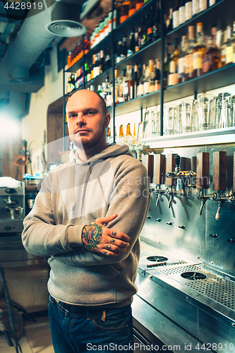 Image of Barman in a pub near beer taps