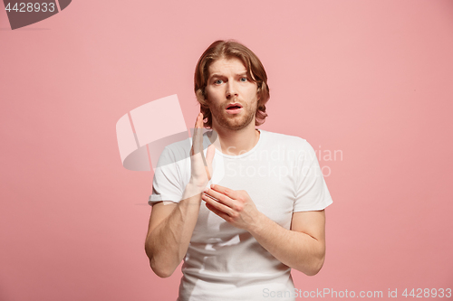 Image of Let me think. Doubtful pensive man with thoughtful expression making choice against pink background