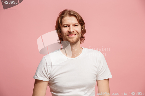 Image of The happy business man standing and smiling against pink background.