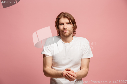 Image of Let me think. Doubtful pensive man with thoughtful expression making choice against pink background