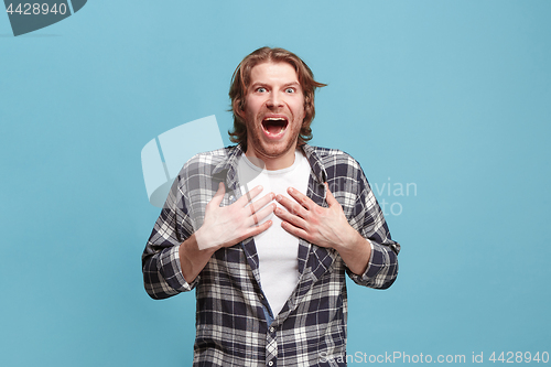 Image of Beautiful man looking suprised isolated on blue