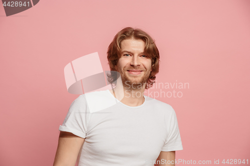 Image of The happy business man standing and smiling against pink background.