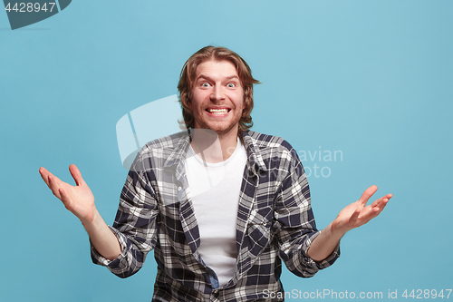 Image of Beautiful man looking suprised isolated on blue