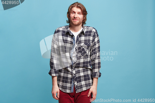 Image of Let me think. Doubtful pensive man with thoughtful expression making choice against blue background