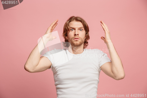 Image of Beautiful man looking suprised isolated on pink