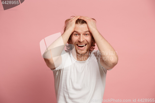 Image of The happy business man standing and smiling against pink background.