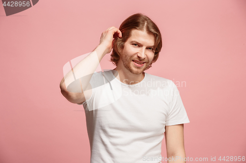 Image of The happy business man standing and smiling against pink background.