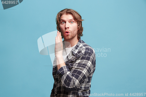 Image of The young man whispering a secret behind her hand