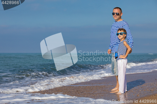 Image of Father and son playing on the beach at the day time. Concept of 