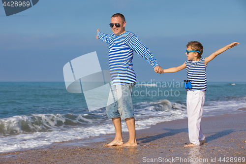 Image of Father and son playing on the beach at the day time. Concept of 