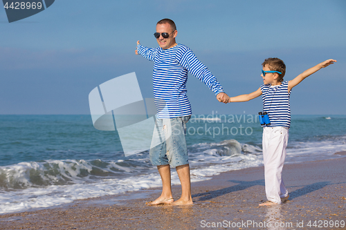 Image of Father and son playing on the beach at the day time. Concept of 