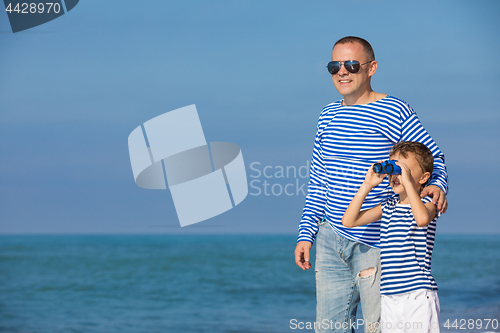 Image of Father and son playing on the beach at the day time. Concept of 